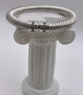 Pulsera rígida de oro blanco 18K, diseño sofisticado con piedras azules que aporta carácter, estilo y elegancia atemporal.