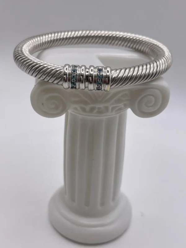 Pulsera rígida de oro blanco 18K, diseño sofisticado con piedras azules que aporta carácter, estilo y elegancia atemporal.