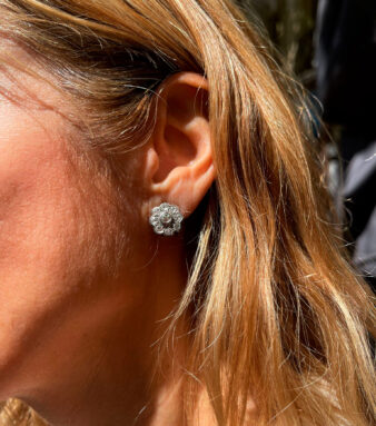 Modelo luciendo pendientes rosetón de oro y diamantes, una joya elegante que destaca por su brillo y diseño sofisticado.