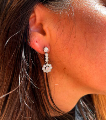 Modelo posando con elegantes pendientes de oro blanco con diamantes que aportan brillo y sofisticación a su estilo.