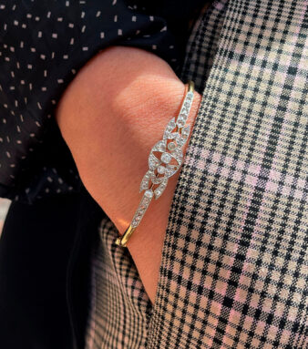 Primer plano de modelo luciendo una pulsera de oro y diamantes con detalle central y estilo moderno que aporta brillo y distinción.