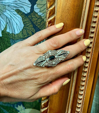 Sofisticada sortija de oro blanco adornada con un zafiro central y detalles de perlas que aportan un estilo elegante y exclusivo.