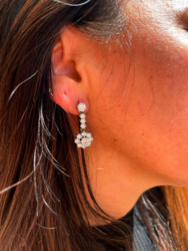 Modelo posando con elegantes pendientes de oro blanco con diamantes que aportan brillo y sofisticación a su estilo.