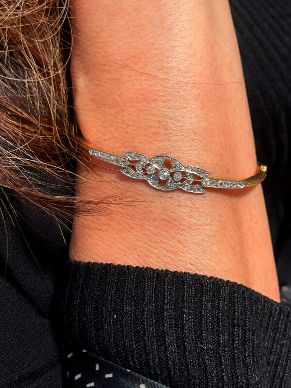 Modelo posando con una elegante pulsera de oro y diamantes con detalle central, destacando su diseño contemporáneo y sofisticado.