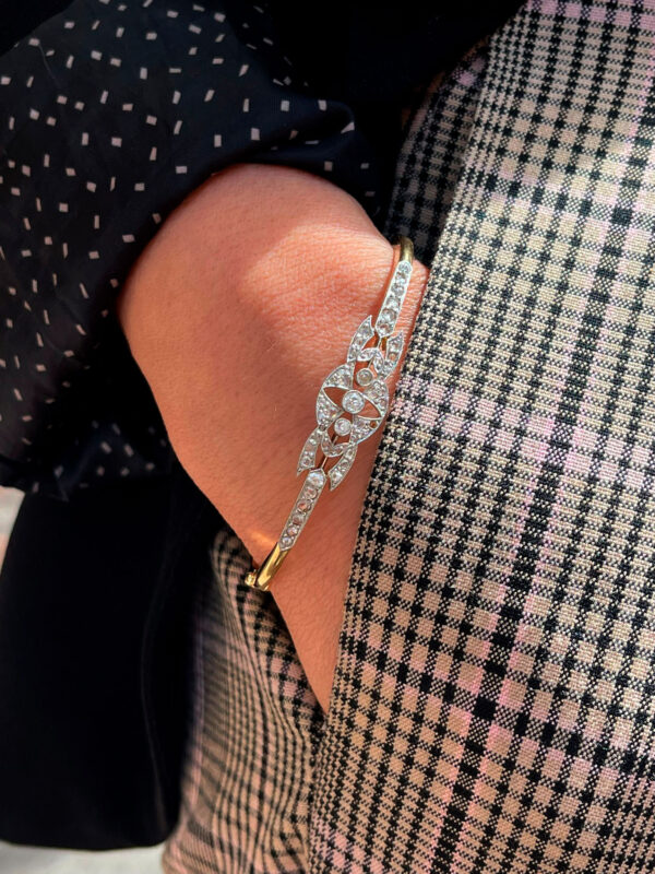 Primer plano de modelo luciendo una pulsera de oro y diamantes con detalle central y estilo moderno que aporta brillo y distinción.