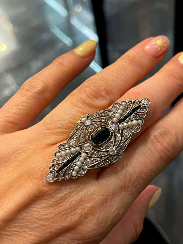 Elegante sortija de oro blanco con zafiro y delicados detalles de perlas, una joya sofisticada que destaca por su refinado tono azul.